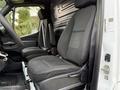 Interior of a 2019 Mercedes-Benz Sprinter featuring two black fabric front seats with a simple dashboard and no visible gear shift