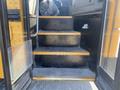 Steps leading into a 2006 Thomas Saf-T-Liner HDX school bus with yellow treads and a rubber mat on the floor