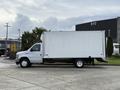 A 2022 Ford E-450 box truck with a white cargo area and black chassis parked on a concrete surface