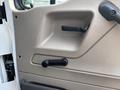 Interior door handle mechanism of a 2006 Sterling Acterra truck with a textured surface and manual window crank located below it