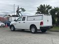 A white 2016 RAM 1500 pickup truck with a bed cover parked on a concrete surface