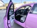 A 2020 Jaguar XE with a pink exterior and a partially open door revealing a black and white interior with a sporty steering wheel and modern dashboard design