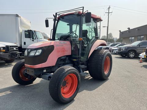 A pink and black 2010 Kubota M6040 tractor with large tires and a cabin, designed for agricultural use