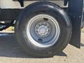 A close-up of a tire on a 2022 Freightliner M2 106 showing the wheel rim and tread with a prominent logo on the tire sidewall