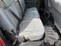 Interior view of a 2013 Ford F-550 showing the rear bench seats upholstered in light gray fabric with seat belts visible