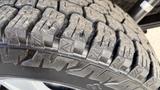 Close-up of a tread pattern on a tire of a 2016 Ford F-150 showing deep grooves and a rugged design for enhanced traction