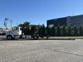 A 2020 Peterbilt 330 truck with a black and chrome body and a mounted crane attachment positioned in a loading configuration