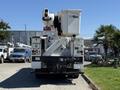 A rear view of a 2013 International 7400 bucket truck with a raised boom and bucket attachment for aerial work