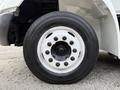 Close-up of the wheel of a 2012 International 4300 featuring a white rim and black tire with visible tread and studs