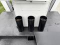 Three black cylindrical exhaust pipes mounted on the top surface of a vehicle