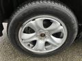 A close-up of a silver alloy wheel from a 2016 Subaru Forester featuring five spokes and a black tire with visible tread patterns