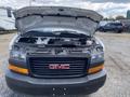 A 2023 GMC Savana with its hood open displaying the engine compartment