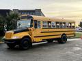 A yellow 2013 International 4300 school bus with black accents and multiple windows on the side.