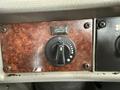 Close-up of a control knob on the dashboard of a 2008 Kenworth T370 featuring a wooden texture with a circular dial and indicator lights