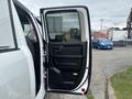 A 2016 RAM 1500 with an open front door showing the interior features including the dashboard and door panel