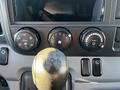 Interior controls of a 2014 Mitsubishi Fuso FE featuring air conditioning dials and a gear shifter