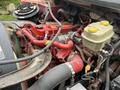 Close-up of the engine compartment of a 2019 Freightliner M2 featuring red and yellow components along with hoses and a coolant reservoir