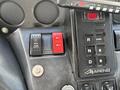 Dashboard controls of a 2012 Autocar Xpert featuring various buttons including a red and a black switch as well as a digital display with the number 121