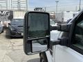 A 2008 Ford F-250 SD side mirror showing a reflection while parked with a view of vehicles in the background