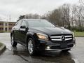 A black 2016 Mercedes-Benz GLA-250 parked on a wet surface showcasing its sleek design and distinctive grille with the Mercedes-Benz logo
