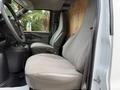 Interior view of a 2018 GMC Savana showing the driver's seat and passenger seat both upholstered in light gray fabric