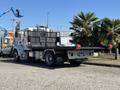 A 2020 Peterbilt 330 flatbed truck parked with a black flatbed and red tow hooks visible at the rear
