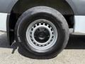 Close-up of a wheel from a 2022 Mercedes-Benz Sprinter featuring a silver hubcap and black tire with visible tread and sidewall markings