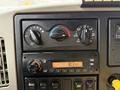 Dashboard controls of a 2011 International 7500 featuring climate control knobs and a radio display showing the time