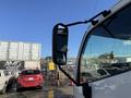 A 2014 Hino 195 truck with a large side mirror reflecting its surroundings