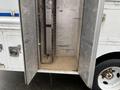 A 2012 Workhorse W62 with open compartments exposing metal shelving and a sandy floor inside the cargo area