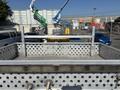 A 2011 Ford F-550 truck bed with a metal platform featuring perforated panels and side rails