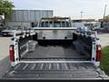 A 2011 Ford F-350 SD truck with a metal toolbox in the bed and a black rubber liner visible in the cargo area