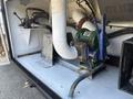 A green and silver pump connected to various pipes and hoses within the interior compartment of a 2008 Peterbilt 340 truck