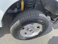 Close-up of a 2014 Ford F-250 SD front wheel featuring a thick tire with a rugged tread pattern and a shiny silver rim