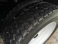 Close-up of a rugged tire from a 2008 Sterling Bullet showcasing deep tread patterns and a white rim