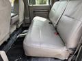 The image shows the rear seating area of a 2008 Ford F-550 with beige upholstery and black floor mats