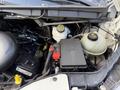 An engine compartment of a 2016 Ford Transit showing various components including the battery fuse box coolant reservoir and several hoses and wires