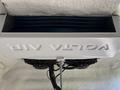 A white air conditioning unit with dual black fans is mounted overhead featuring the label VOTL AIR