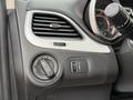 Interior control panel of a 2013 Dodge Journey featuring knobs for headlights and other settings along with a circular air vent and a directional control stalk