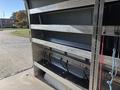 Interior shelving unit of a 2024 Mercedes-Benz Sprinter 2500 with multiple open compartments and straps for securing cargo