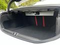 The trunk of a 2023 Alfa Romeo Giulia showing a spacious cargo area with black carpeting and red accent stripes on the interior walls