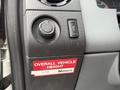 Close-up of the dashboard controls of a 2012 Ford F-450 SD featuring a dial for lights and a button along with a label indicating overall vehicle height