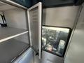 Interior view of a 2013 Chevrolet Express showing an open cabinet door and a glimpse of the dashboard and front seats