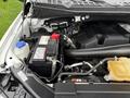 Close-up of the engine compartment of a 2018 Ford F-150 showing the battery and various engine components with visible hoses and cables