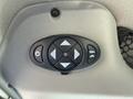 A black control panel featuring directional arrows and buttons for operating various features in a vehicle