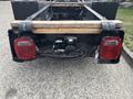 The rear of a 2020 Lion Lion6 electric vehicle chassis showing the tail lights and the wooden mounting beam attached to the frame