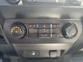 Control panel of a 2019 Ford F-150 featuring climate control buttons and knobs for fan speed temperature and air conditioning settings