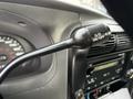Close-up of the gear shift lever in a 2011 Ford Ranger with an overdrive on/off toggle and instrument panel in the background showing speedometer and dashboard controls