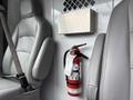 A 2017 Ford Econoline interior featuring gray leather seats and a red fire extinguisher mounted on the wall