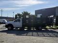 A white 2015 RAM 4500 flatbed truck with a wooden stake body configuration parked on a driveway